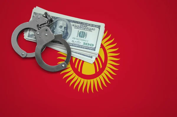 Kyrgyzstan flag  with handcuffs and a bundle of dollars. The concept of breaking the law and thieves crimes.