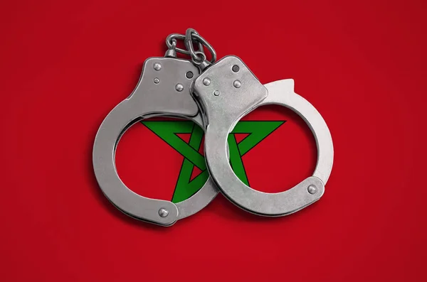 Morocco flag  and police handcuffs. The concept of observance of the law in the country and protection from crime.