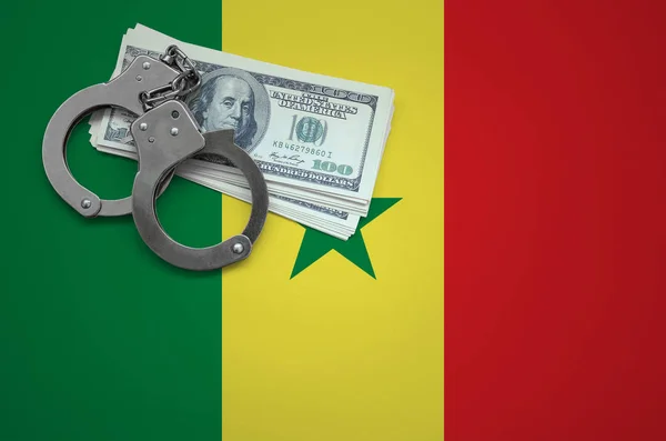 Senegal flag  with handcuffs and a bundle of dollars. The concept of breaking the law and thieves crimes.