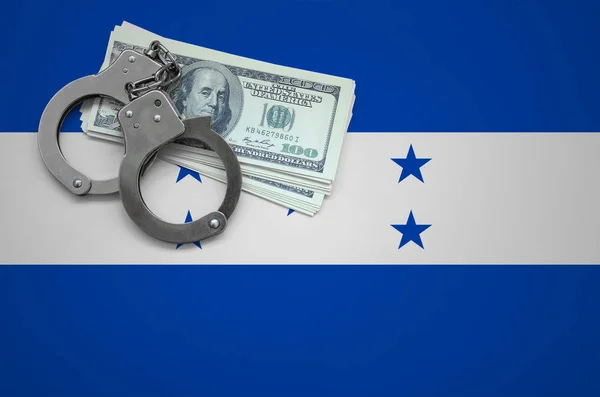 Honduras flag  with handcuffs and a bundle of dollars. The concept of breaking the law and thieves crimes.