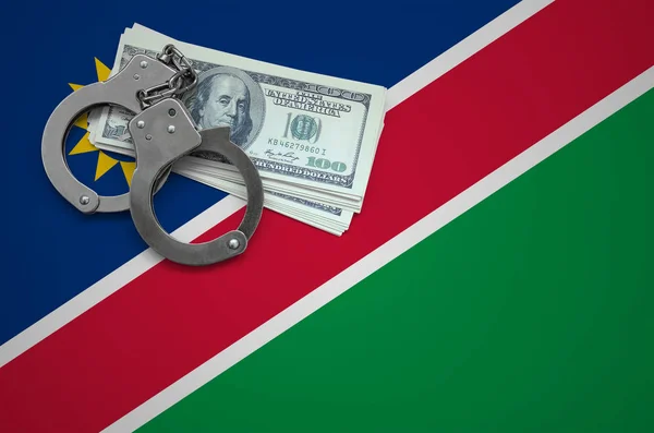 Namibia flag  with handcuffs and a bundle of dollars. The concept of breaking the law and thieves crimes.