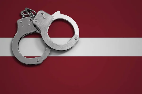 拉脱维亚国旗和警察手铐 论我国的犯罪与违法行为概念 — 图库照片