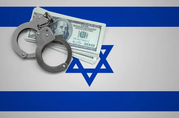 Israel flag  with handcuffs and a bundle of dollars. The concept of breaking the law and thieves crimes.