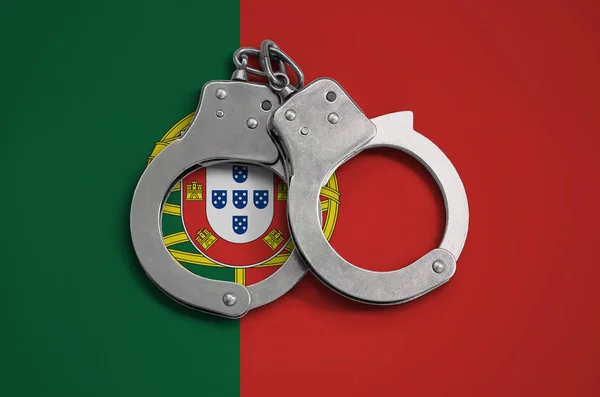 Portugal flag  and police handcuffs. The concept of observance of the law in the country and protection from crime.