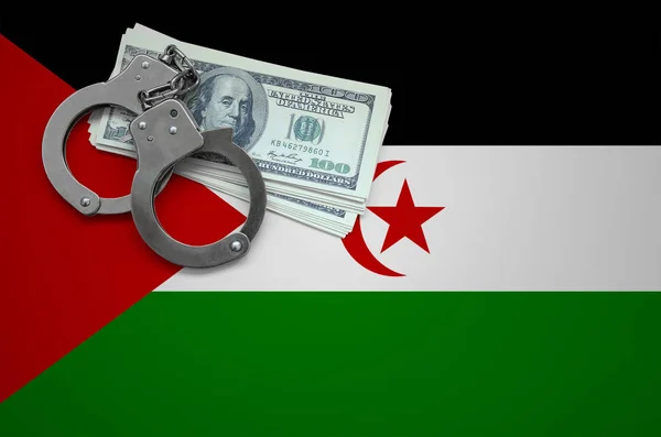 Western Sahara flag  with handcuffs and a bundle of dollars. The concept of breaking the law and thieves crimes.