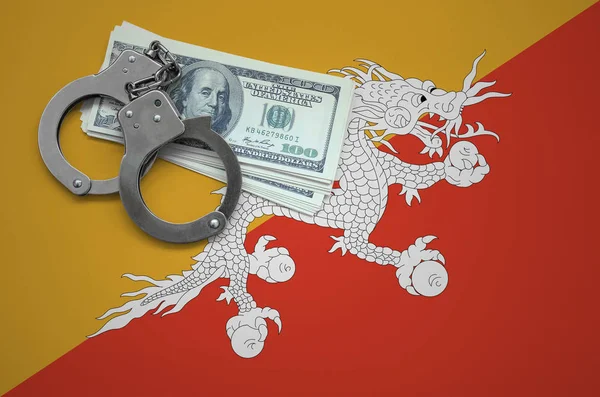 Bhutan flag  with handcuffs and a bundle of dollars. The concept of breaking the law and thieves crimes.