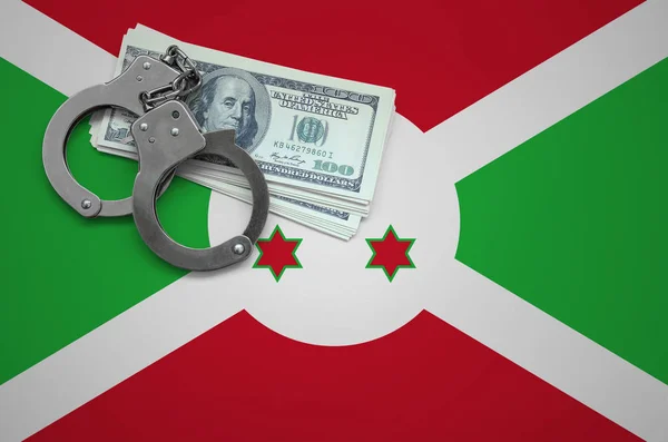 Burundi flag  with handcuffs and a bundle of dollars. The concept of breaking the law and thieves crimes.