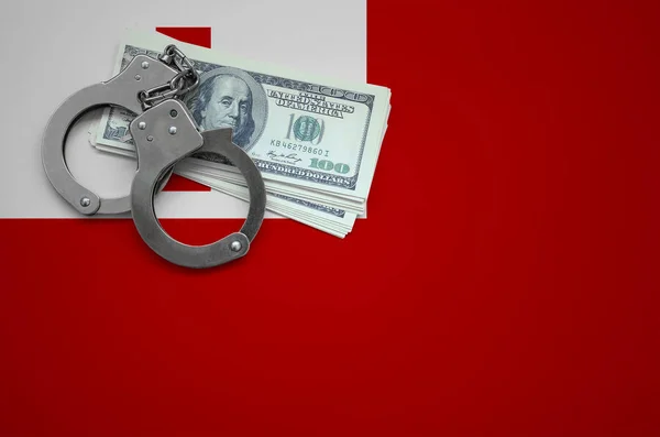 Tonga flag  with handcuffs and a bundle of dollars. The concept of breaking the law and thieves crimes.