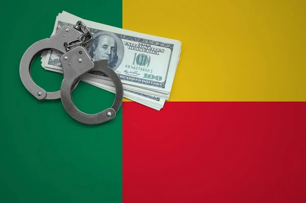 Benin flag  with handcuffs and a bundle of dollars. The concept of breaking the law and thieves crimes.