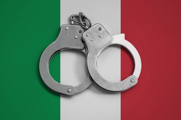 Italy flag  and police handcuffs. The concept of observance of the law in the country and protection from crime.