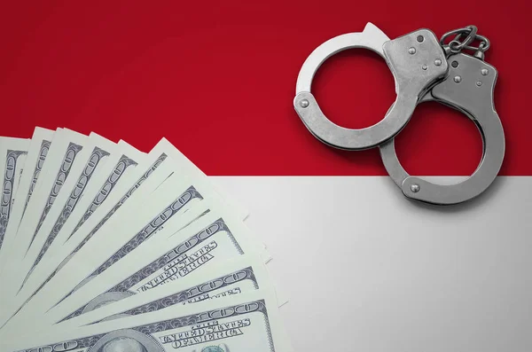 Indonesia flag  with handcuffs and a bundle of dollars. The concept of illegal banking operations in US currency.