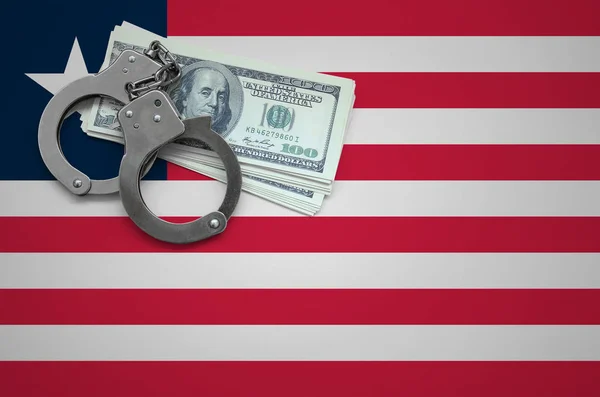 Liberia flag  with handcuffs and a bundle of dollars. The concept of breaking the law and thieves crimes.