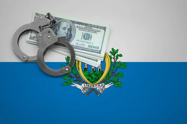 San Marino flag  with handcuffs and a bundle of dollars. The concept of breaking the law and thieves crimes.