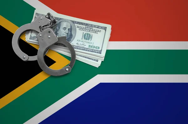 South Africa flag  with handcuffs and a bundle of dollars. The concept of breaking the law and thieves crimes.