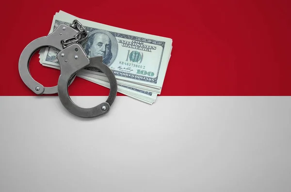 Indonesia flag  with handcuffs and a bundle of dollars. The concept of breaking the law and thieves crimes.