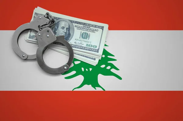 Lebanon flag  with handcuffs and a bundle of dollars. The concept of breaking the law and thieves crimes.