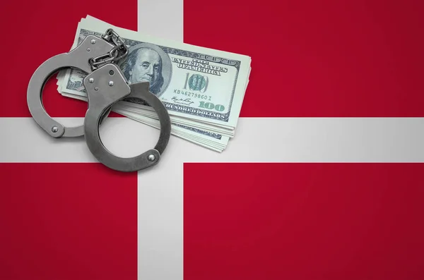 Denmark flag  with handcuffs and a bundle of dollars. The concept of breaking the law and thieves crimes.