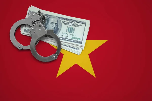Vietnam flag  with handcuffs and a bundle of dollars. The concept of breaking the law and thieves crimes.