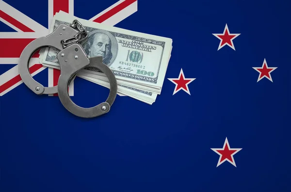 New Zealand flag  with handcuffs and a bundle of dollars. The concept of breaking the law and thieves crimes.