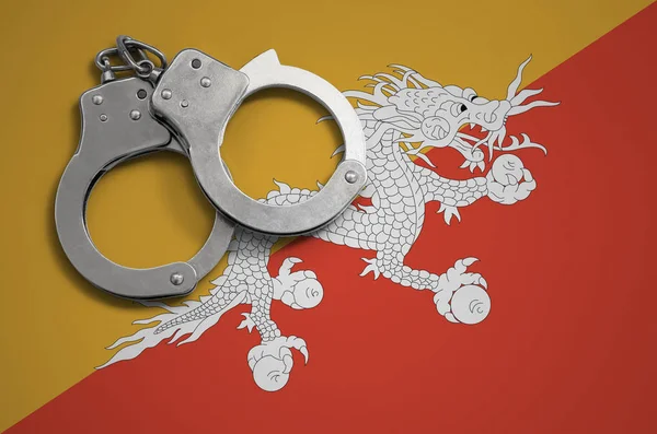 Bhutan flag  and police handcuffs. The concept of crime and offenses in the country.