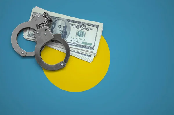 Palau flag  with handcuffs and a bundle of dollars. The concept of breaking the law and thieves crimes.