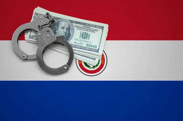 Paraguay flag  with handcuffs and a bundle of dollars. The concept of breaking the law and thieves crimes.