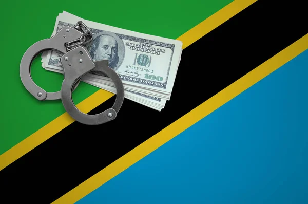 Tanzania flag  with handcuffs and a bundle of dollars. The concept of breaking the law and thieves crimes.