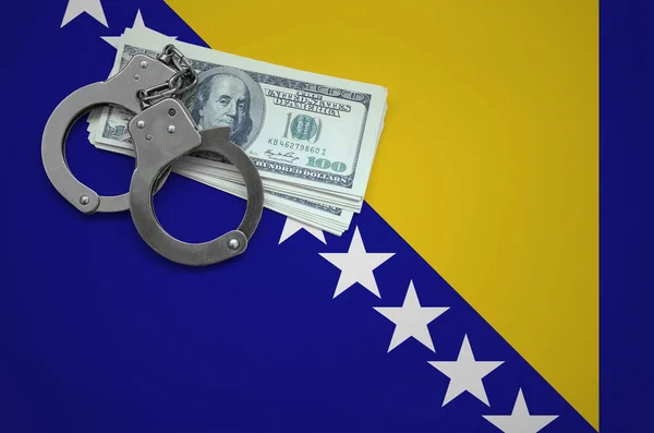Bosnia and Herzegovina flag  with handcuffs and a bundle of dollars. The concept of breaking the law and thieves crimes.