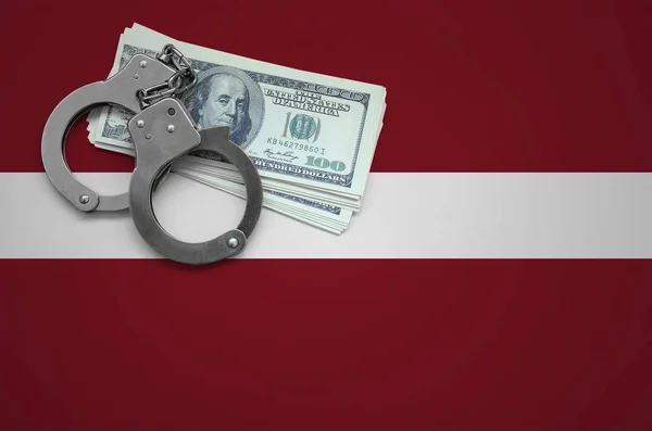 Latvia flag  with handcuffs and a bundle of dollars. The concept of breaking the law and thieves crimes.