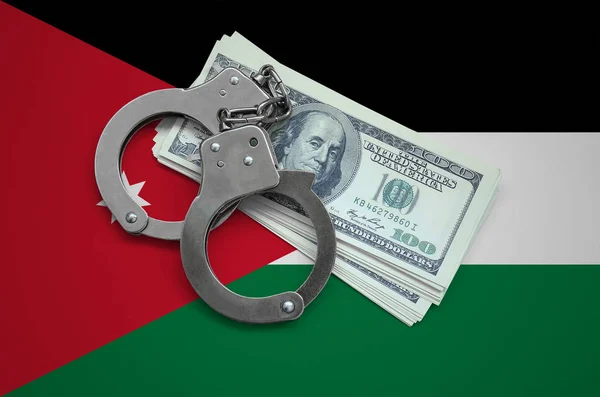 Jordan flag  with handcuffs and a bundle of dollars. Currency corruption in the country. Financial crimes.
