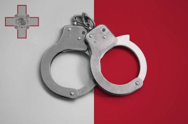 Malta flag  and police handcuffs. The concept of observance of the law in the country and protection from crime. clipart