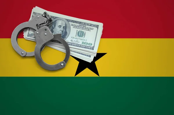 Ghana flag  with handcuffs and a bundle of dollars. The concept of breaking the law and thieves crimes.
