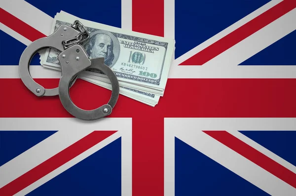 Great britain flag  with handcuffs and a bundle of dollars. The concept of breaking the law and thieves crimes.