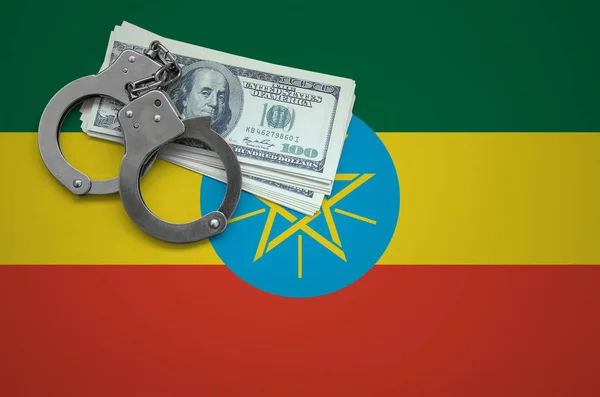 Ethiopia flag  with handcuffs and a bundle of dollars. The concept of breaking the law and thieves crimes.