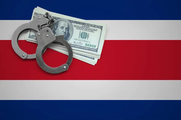 Costa Rica flag  with handcuffs and a bundle of dollars. The concept of breaking the law and thieves crimes.