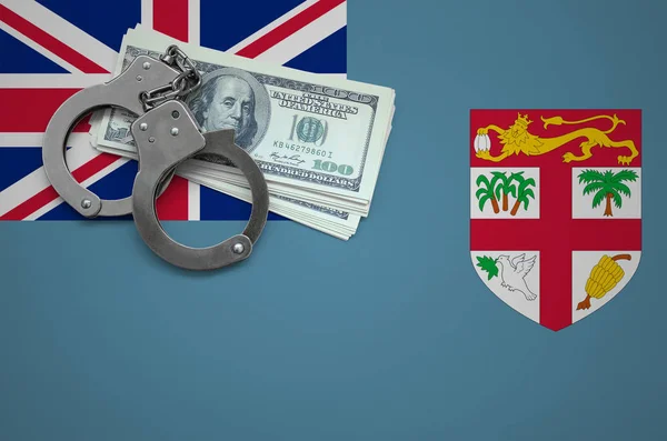 Fiji flag  with handcuffs and a bundle of dollars. The concept of breaking the law and thieves crimes.