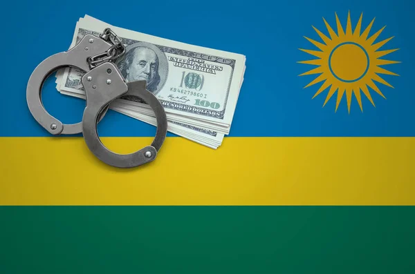 Rwanda flag  with handcuffs and a bundle of dollars. The concept of breaking the law and thieves crimes.