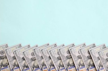 Satır bir ABD dolar faturaları yeni bir tasarım üzerinde bir açık mavi renkli yatıyor.