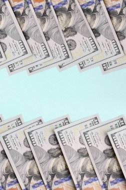 Satır bir ABD dolar faturaları yeni bir tasarım üzerinde bir açık mavi renkli yatıyor.