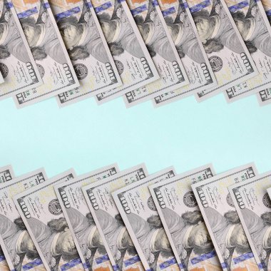 Satır bir ABD dolar faturaları yeni bir tasarım üzerinde bir açık mavi renkli yatıyor.