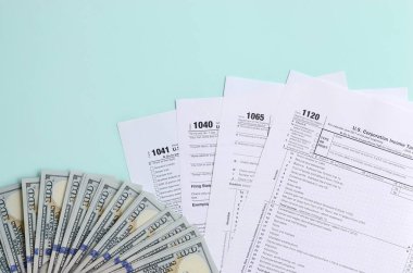 Formları yalan yüz dolar faturaları ve ışık mavi zemin üzerine mavi kalem yakın vergi. Gelir vergisi beyannamesi.