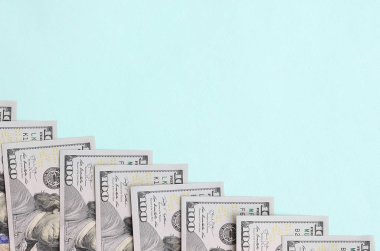 Satır bir ABD dolar faturaları yeni bir tasarım üzerinde bir açık mavi renkli yatıyor.
