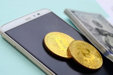 Vergi formları, yüz dolar faturaları ve açık mavi renkli smartphone ile Bitcoins yatıyor. Gelir vergisi beyannamesi.