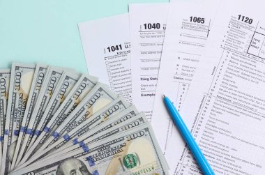 Formları yalan yüz dolar faturaları ve ışık mavi zemin üzerine mavi kalem yakın vergi. Gelir vergisi beyannamesi.
