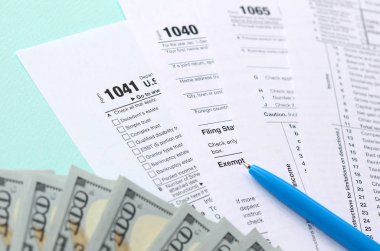 Formları yalan yüz dolar faturaları ve ışık mavi zemin üzerine mavi kalem yakın vergi. Gelir vergisi beyannamesi.