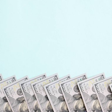 Satır bir ABD dolar faturaları yeni bir tasarım üzerinde bir açık mavi renkli yatıyor.