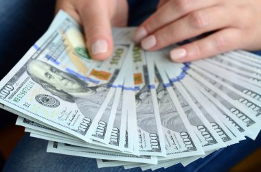 A yelpaze-in yüz dolar Bono tutan bir kız.