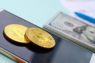 Vergi formları, yüz dolar faturaları ve açık mavi renkli smartphone ile Bitcoins yatıyor. Gelir vergisi beyannamesi.
