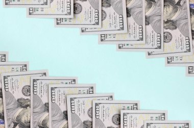 Satır bir ABD dolar faturaları yeni bir tasarım üzerinde bir açık mavi renkli yatıyor.