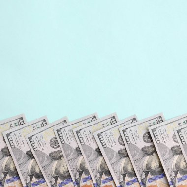 Satır bir ABD dolar faturaları yeni bir tasarım üzerinde bir açık mavi renkli yatıyor.